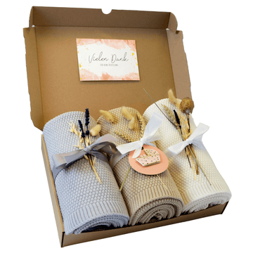 Geschenkset Baby Cloud bestehend aus 3 Strickdecken in grau, beige, crème-weiß, mit Schleife und Blumen verpackt