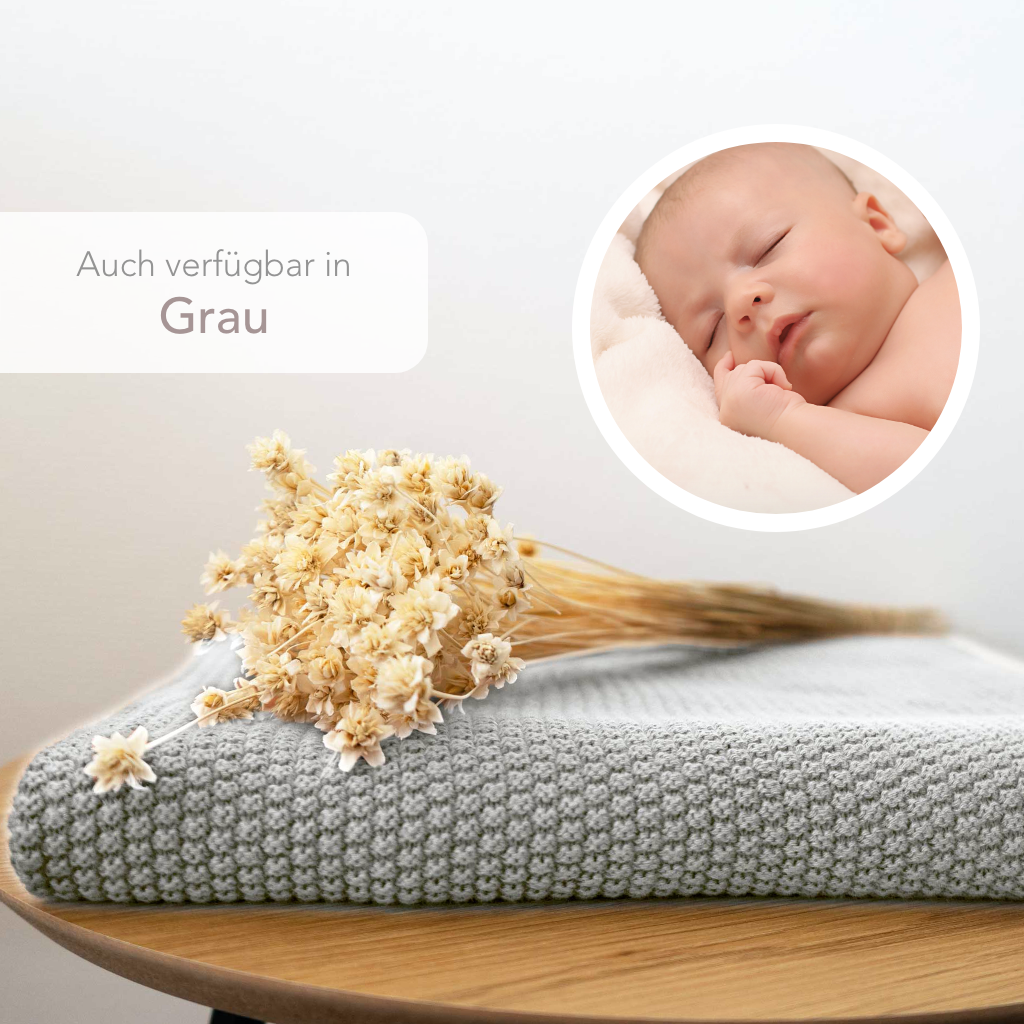 Strickdecke von Kinderzimmer.de in crème-weiss, dargestellt mit schlafendem Baby